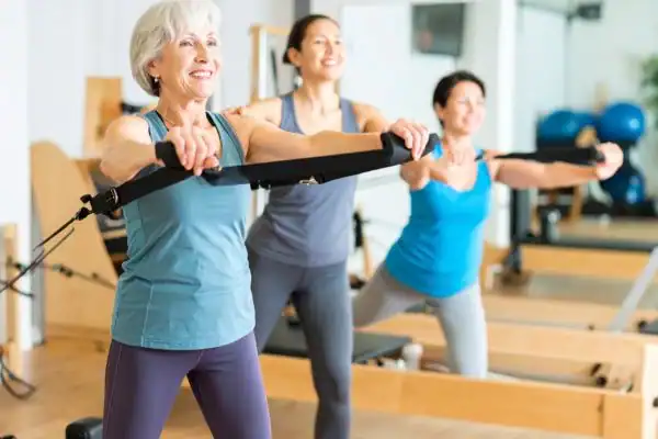 Toning Arms After 60: Empowering Womens Fitness Through Effective Weight Training 2 older woman doing weight training Tilbury and resistance in the gym to tone upper arms