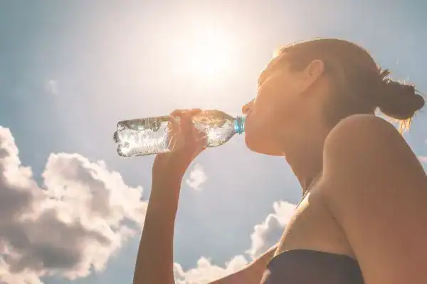 Hydration: The Secret Ingredient for a Toned Stomach and Enhanced Fitness 3 Image of woman drinking water to hydrate Tilbury after run.