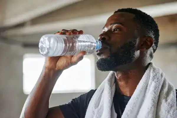 Hydration: The Secret Ingredient for a Toned Stomach and Enhanced Fitness 1 Image of man drinking water to improve hydration Tilbury after work out.